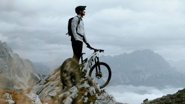 Mountainbiker mit Rad auf einem Felsgrat in den Dolomiten, Standbild aus dem Husqvarna-Film